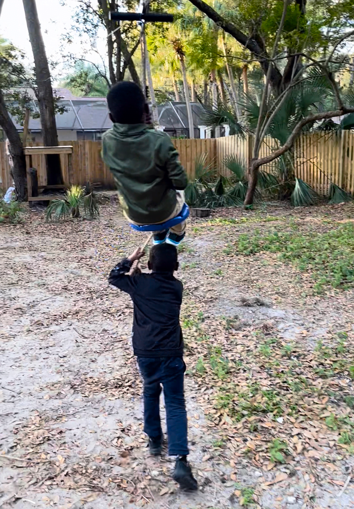 Boys zip lining outdoors 